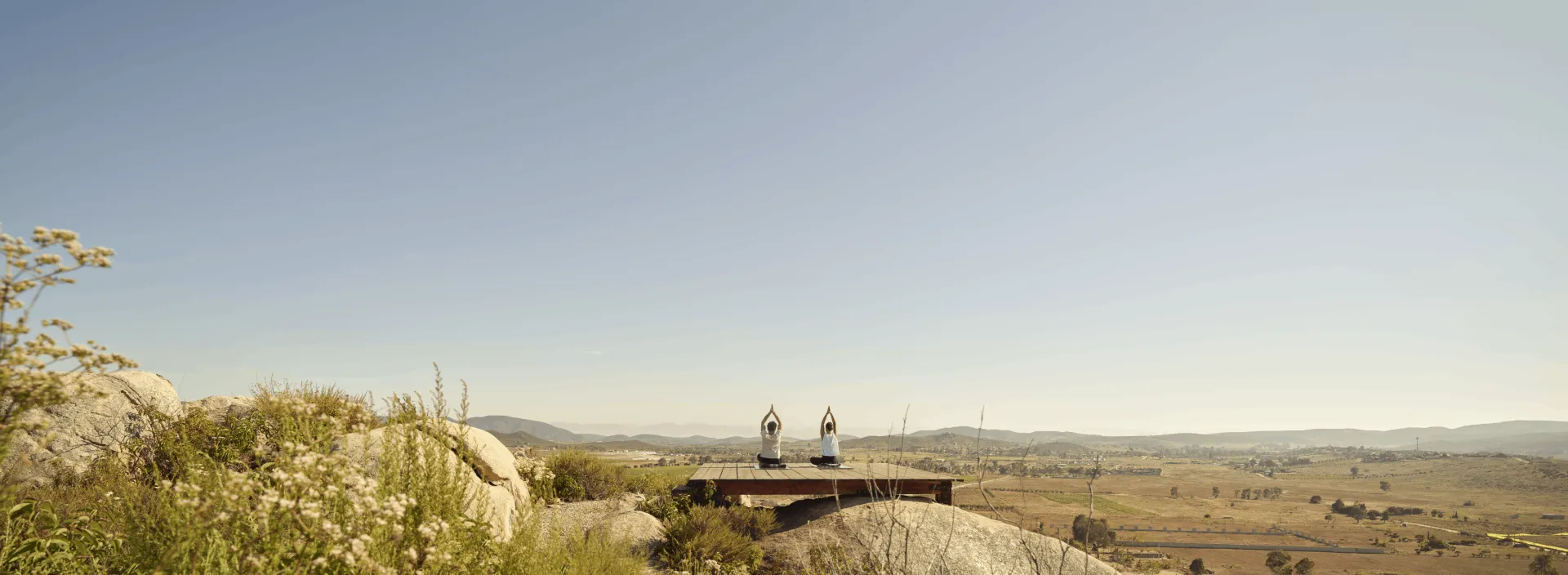 Two people practicing yoga in nature in Valle De Guadalupe