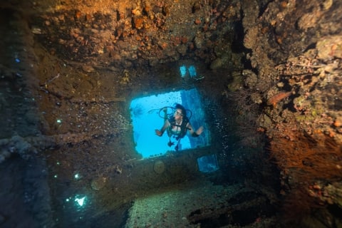 A person underwater exploring the Rannamaari Shipwreck near Dhawa Ihuru in the Maldives