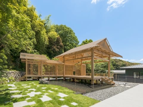 Banyan Tree Higashiyama Kyoto’s bamboo pavillion - A wooden structure with a pond and grass and trees in the background